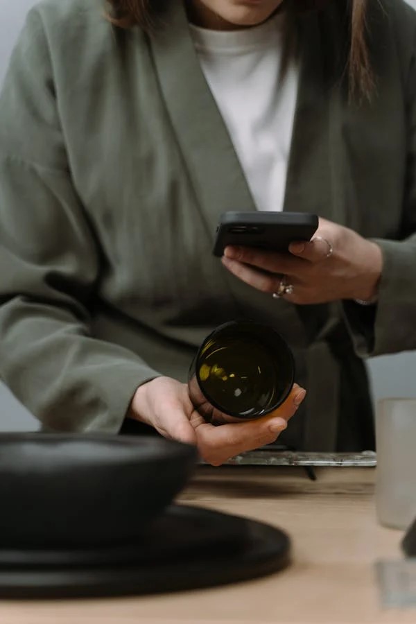 a person holding a glass and a phone